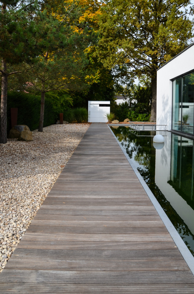 Large contemporary partial sun garden in Munich with a garden path and decking.