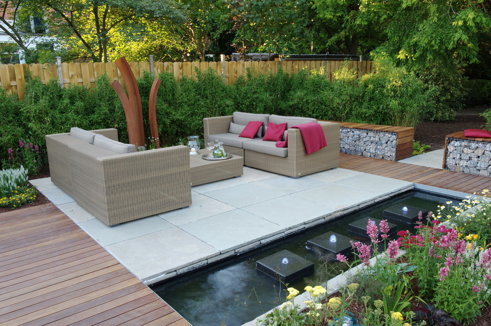 Idées déco pour un jardin contemporain de taille moyenne avec un point d'eau et une terrasse en bois.