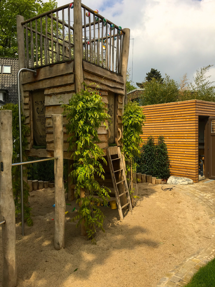 Ejemplo de jardín rústico con parque infantil y exposición parcial al sol