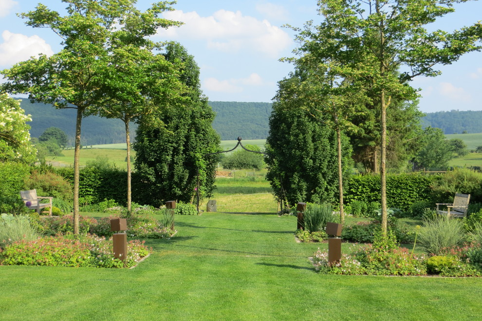 Ejemplo de camino de jardín tradicional extra grande en verano en ladera con exposición total al sol y jardín francés