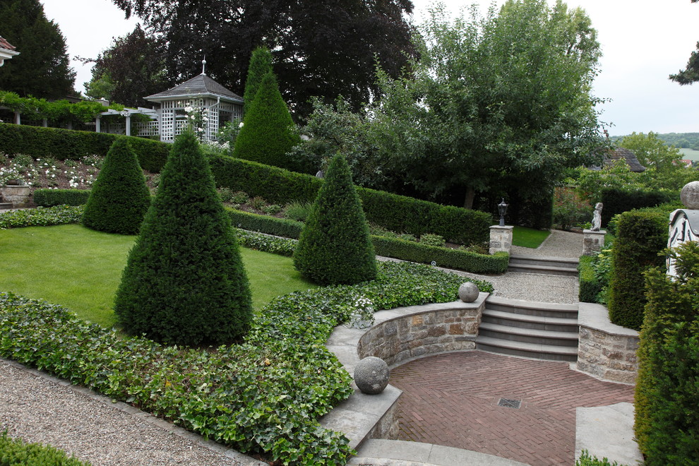 Inspiration för en stor vintage formell trädgård i full sol i slänt, med en trädgårdsgång och grus
