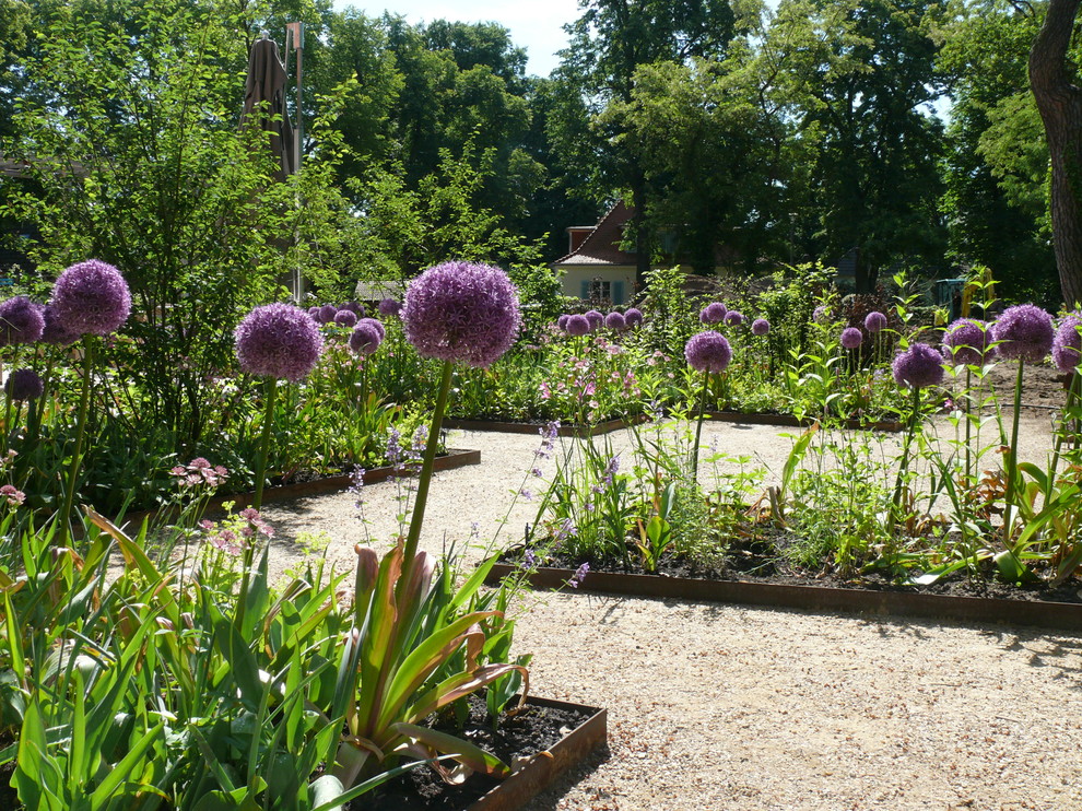 Foto di un giardino tradizionale esposto in pieno sole di medie dimensioni in estate con un ingresso o sentiero e ghiaia