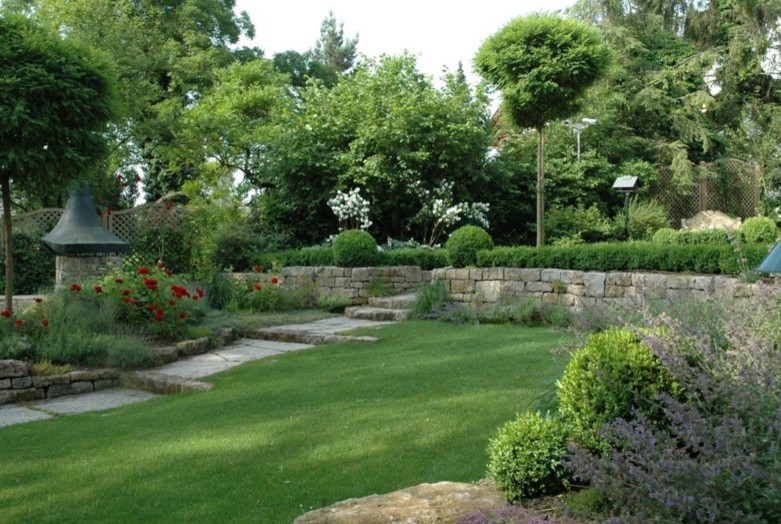 Idées déco pour un aménagement d'entrée ou allée de jardin latéral campagne de taille moyenne et l'été avec une exposition ensoleillée et des pavés en pierre naturelle.
