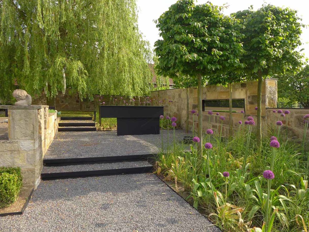 На фото: большой участок и сад в современном стиле с подпорной стенкой, полуденной тенью и покрытием из гравия