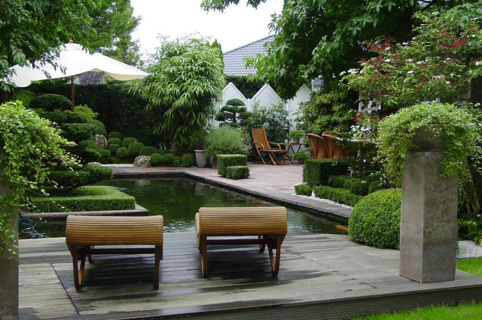Imagen de jardín de estilo zen de tamaño medio en verano en patio lateral con exposición parcial al sol