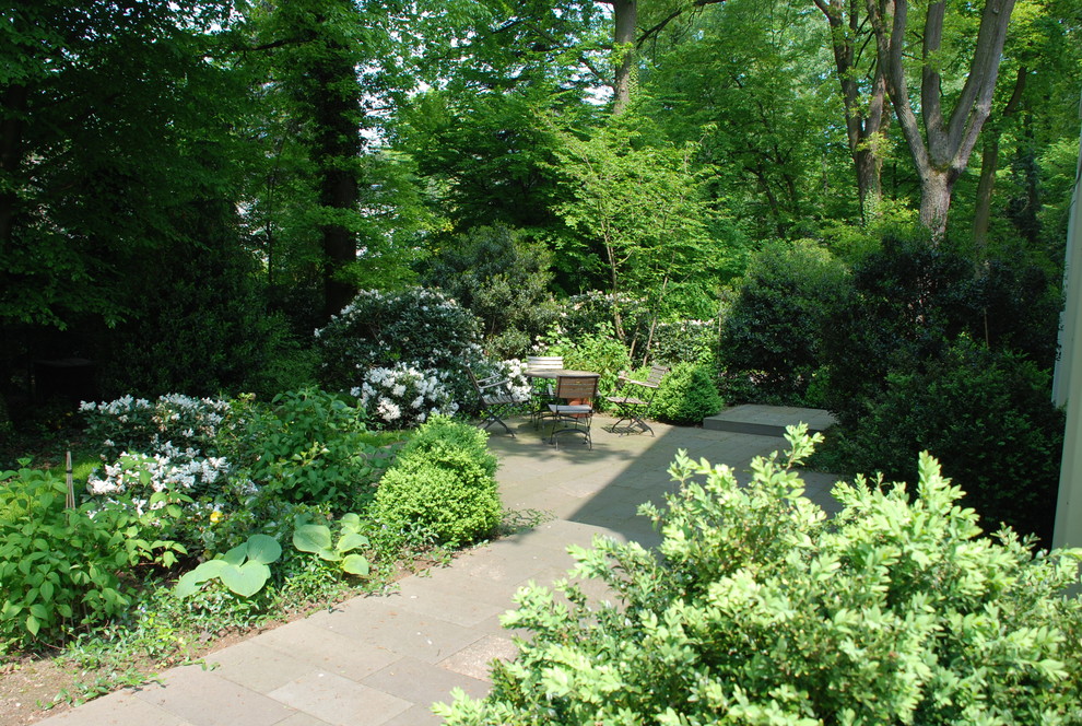 Esempio di un giardino classico esposto a mezz'ombra di medie dimensioni con un ingresso o sentiero e pavimentazioni in pietra naturale