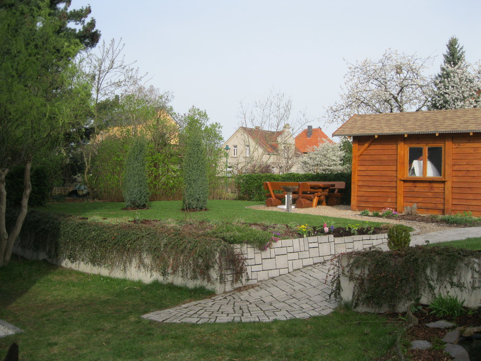 Idéer för att renovera en stor vintage trädgård, med en stödmur