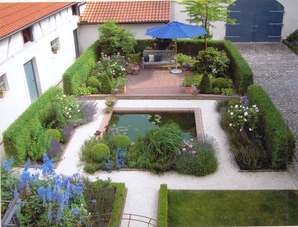 Imagen de camino de jardín campestre de tamaño medio en patio con jardín francés, gravilla y exposición total al sol