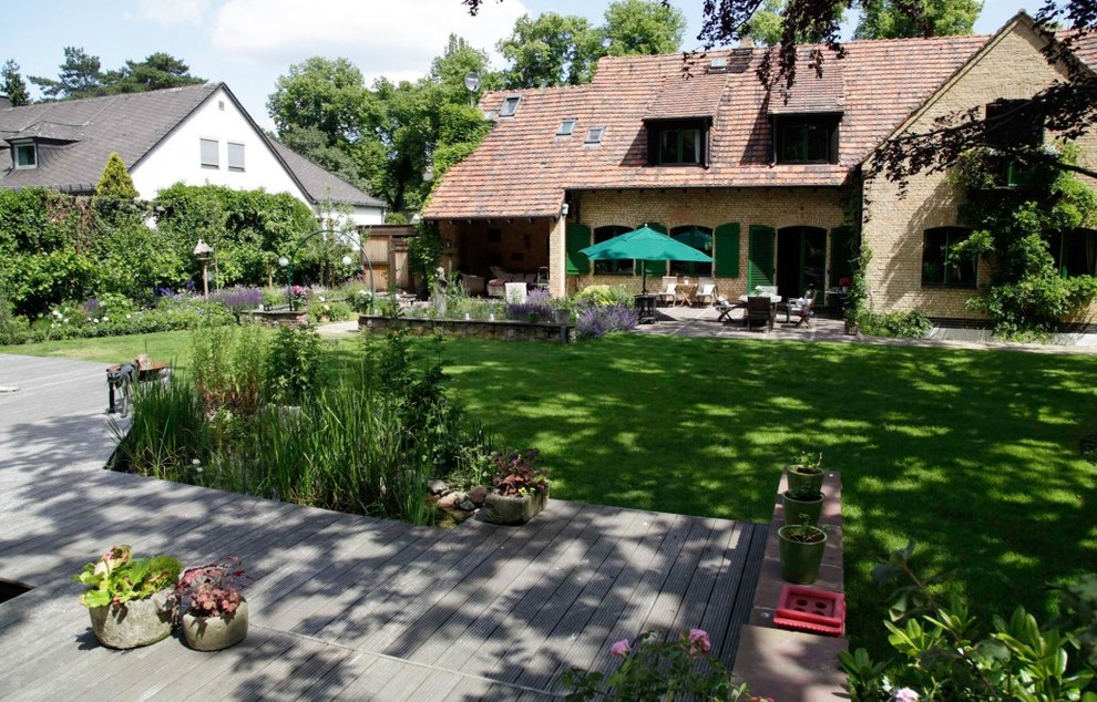Photo of a large contemporary courtyard garden for summer in Berlin with a water feature and decking.