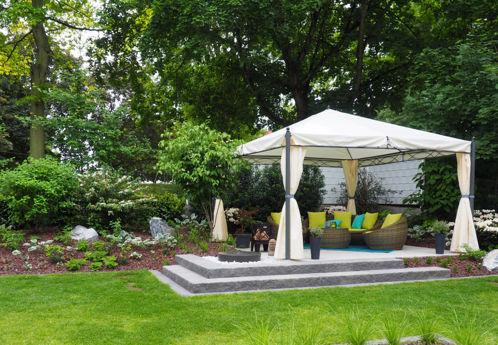 Foto de jardín actual de tamaño medio en patio lateral con jardín francés y fuente