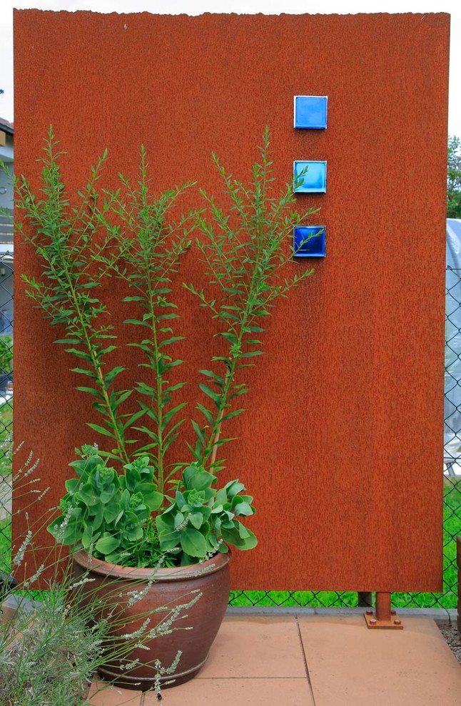 Kleiner, Halbschattiger Mediterraner Gemüsegarten im Sommer, neben dem Haus mit Natursteinplatten in Frankfurt am Main