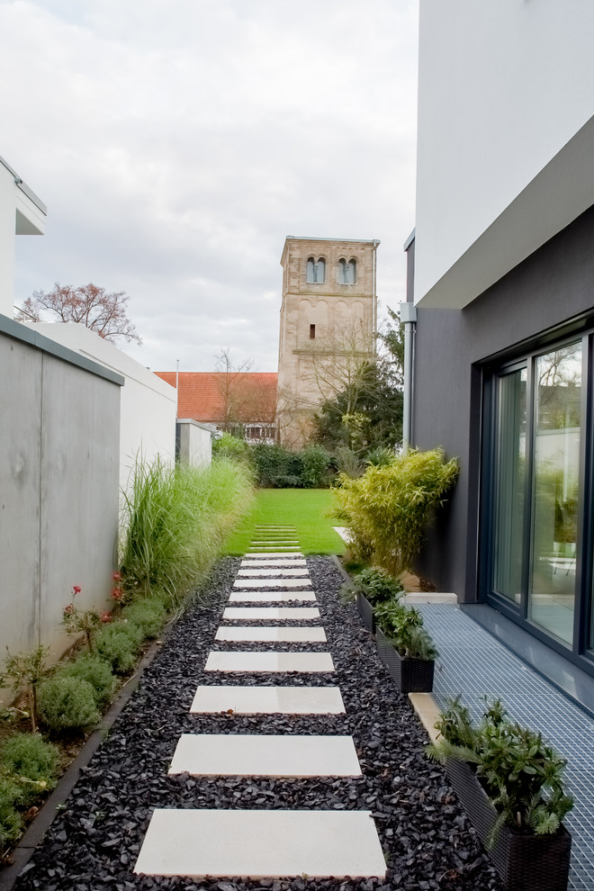 Large contemporary side formal partial sun garden in Dusseldorf with a garden path.