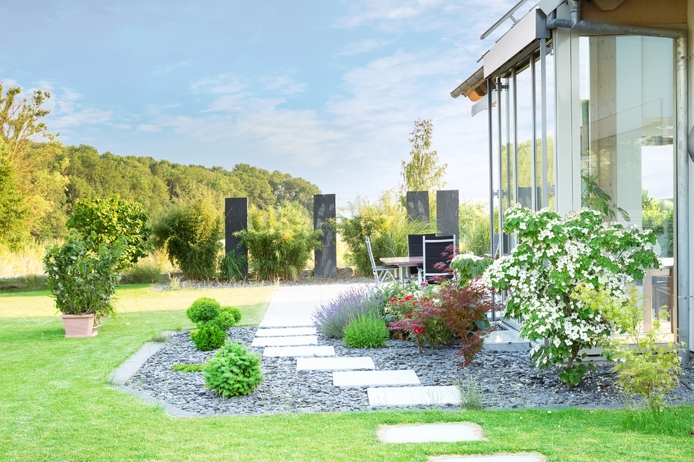 Kleiner Moderner Garten mit Auffahrt, direkter Sonneneinstrahlung und Natursteinplatten in Stuttgart