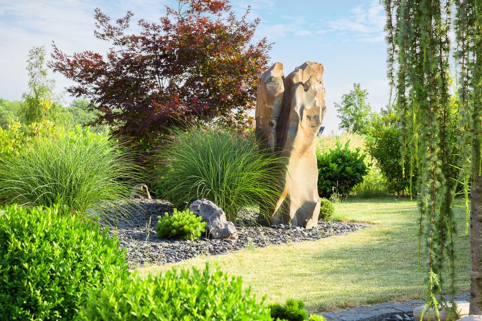 Modelo de jardín contemporáneo grande en patio delantero con exposición total al sol y adoquines de piedra natural