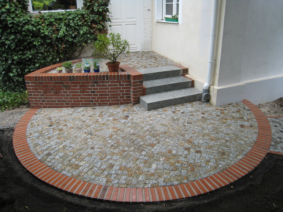Design ideas for a medium sized rural front driveway full sun garden for spring in Berlin with a garden path and brick paving.