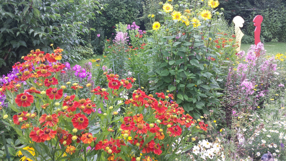 Kleiner Country Garten im Sommer, neben dem Haus mit Blumenbeet und direkter Sonneneinstrahlung in Hamburg