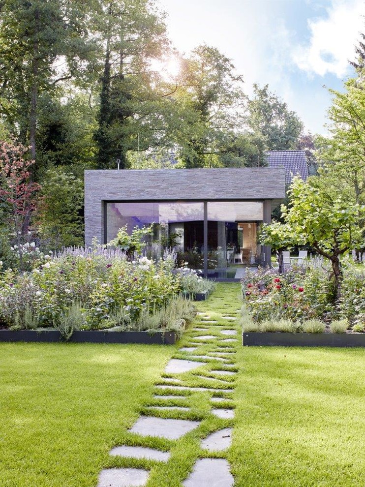 Design ideas for a large contemporary back partial sun garden for summer in Cologne with a garden path and natural stone paving.