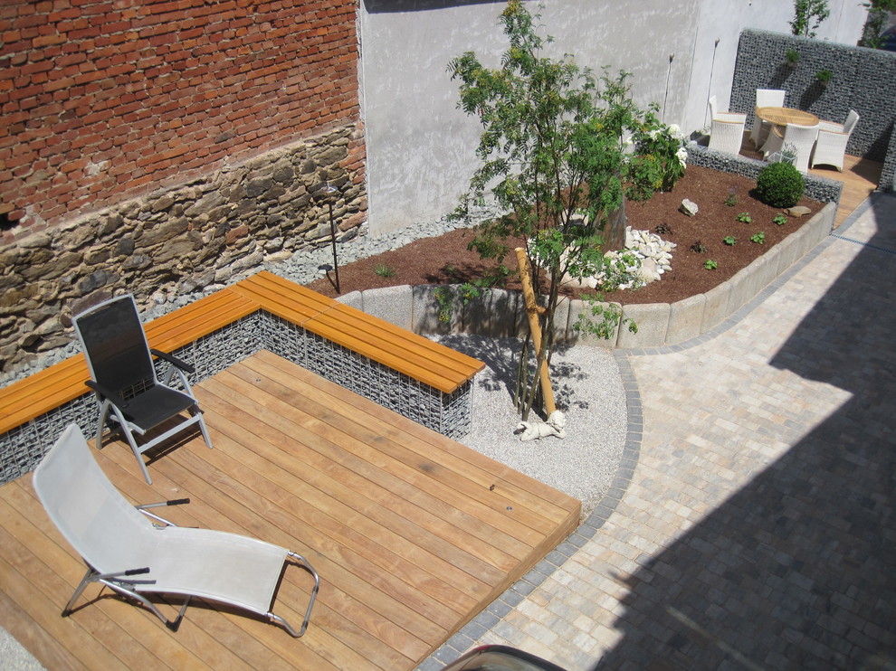 Idées déco pour un grand jardin arrière contemporain au printemps avec une exposition ensoleillée et des pavés en pierre naturelle.
