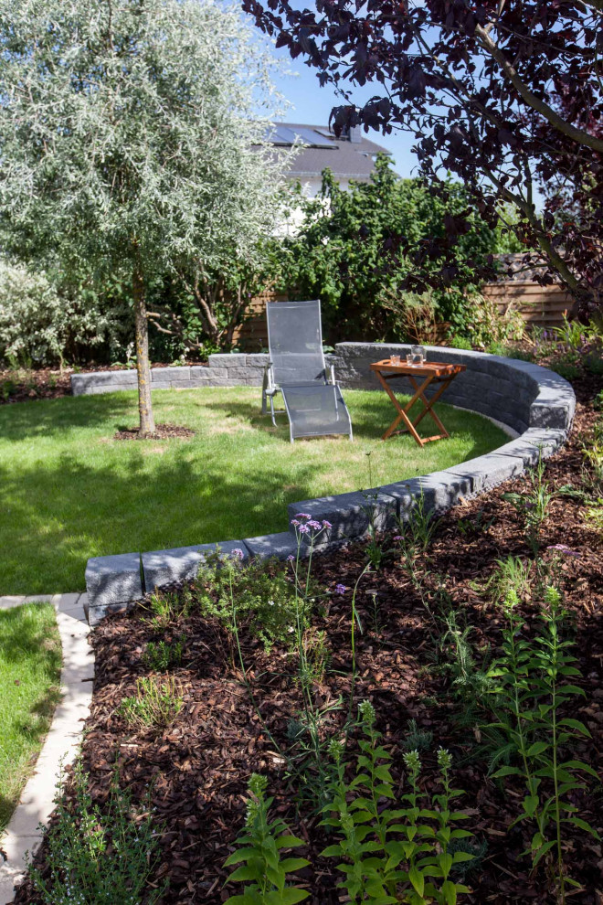 Foto de jardín rústico con macetero elevado y adoquines de hormigón