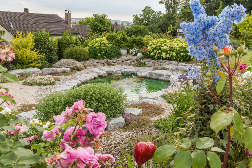 Foto de jardín tradicional grande en patio con estanque, exposición total al sol y adoquines de piedra natural