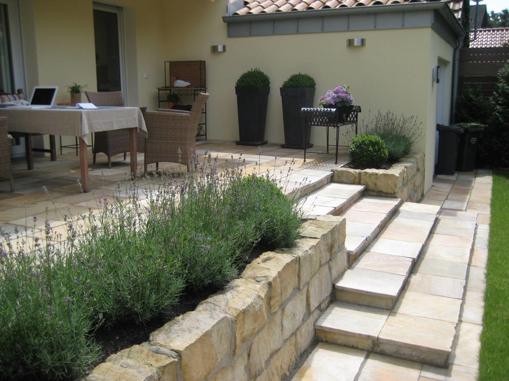 Immagine di un giardino design dietro casa in estate con pavimentazioni in pietra naturale