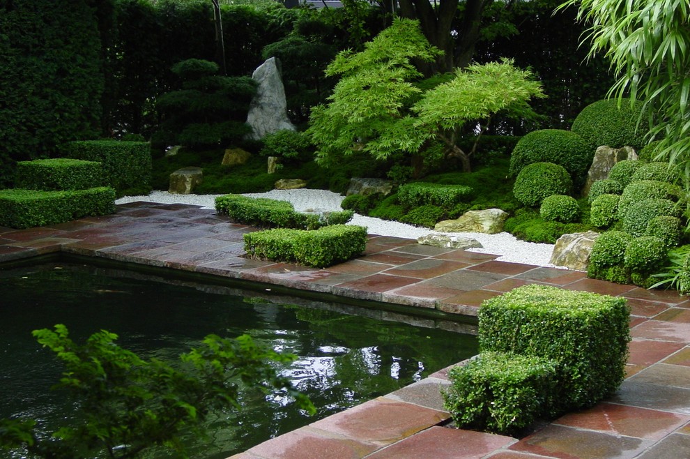 Imagen de jardín asiático de tamaño medio en verano en patio con jardín francés, estanque, exposición parcial al sol y adoquines de piedra natural