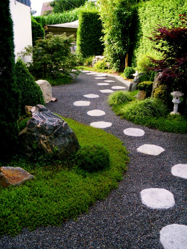 Immagine di un grande giardino etnico in ombra con un ingresso o sentiero, passi giapponesi e ghiaia