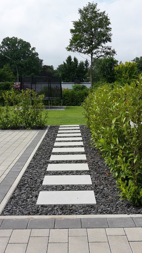 Esempio di un giardino design esposto in pieno sole di medie dimensioni e nel cortile laterale in estate con un ingresso o sentiero e pavimentazioni in cemento