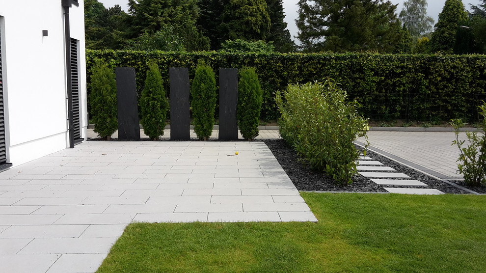 This is an example of a mid-sized contemporary full sun side yard concrete paver garden path in Hamburg for summer.