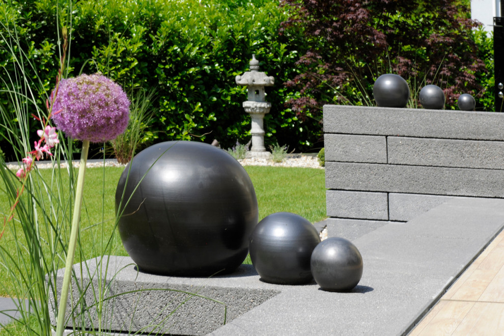Ejemplo de jardín de estilo zen en verano con roca decorativa