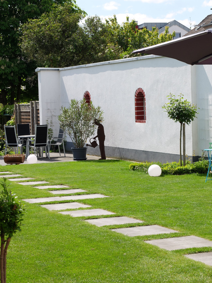 Esempio di un giardino formale mediterraneo esposto in pieno sole di medie dimensioni e dietro casa in estate con un ingresso o sentiero e pavimentazioni in cemento