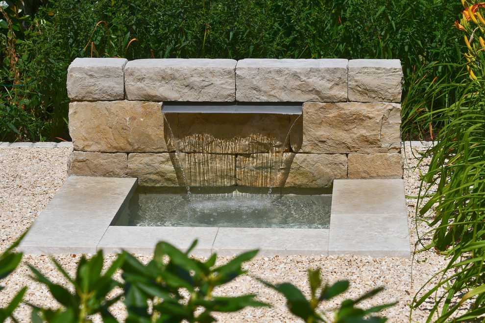 Photo of a medium sized contemporary courtyard xeriscape partial sun garden for summer in Stuttgart with a water feature and natural stone paving.