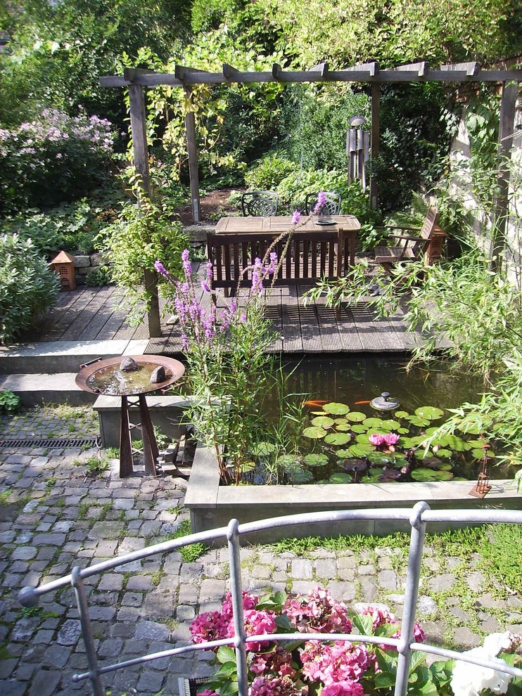 Kleiner, Halbschattiger Uriger Garten im Sommer mit Dielen und Pergola in Sonstige