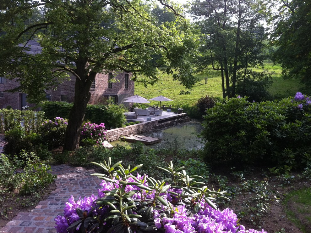 Esempio di un ampio giardino tradizionale in ombra in estate con un ingresso o sentiero, un pendio, una collina o una riva e pavimentazioni in pietra naturale