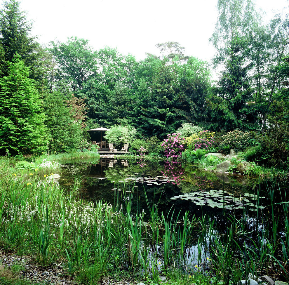 Geräumiger, Halbschattiger Country Kiesgarten im Sommer, hinter dem Haus mit Wasserspiel in Hamburg