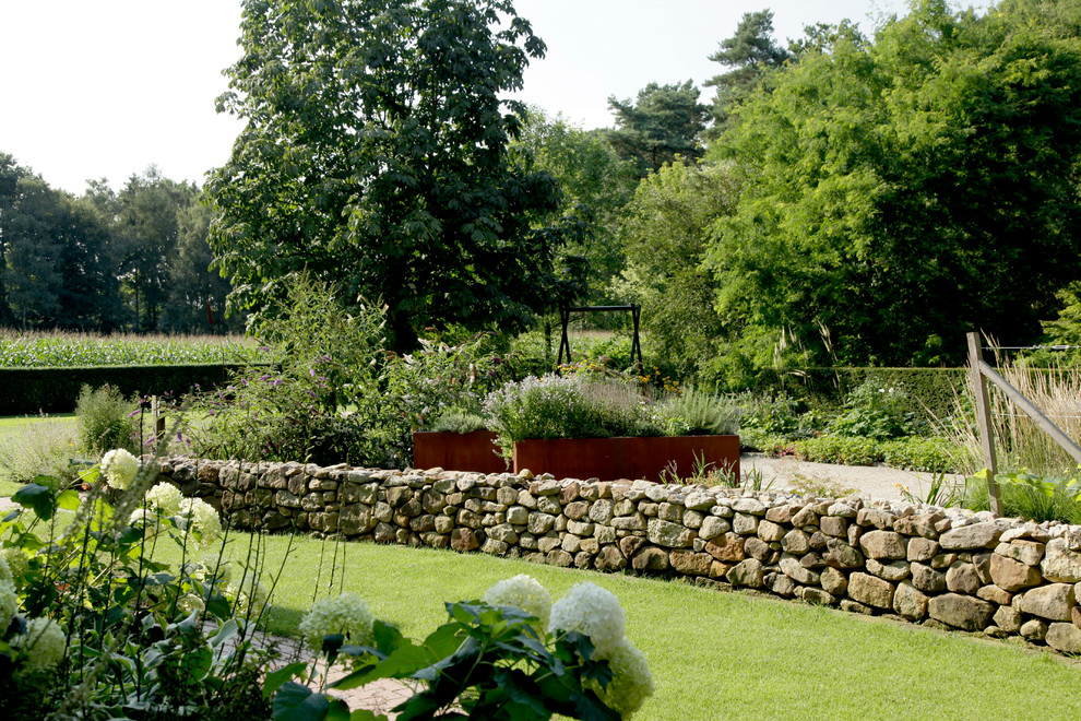 Foto di un giardino country con un muro di contenimento
