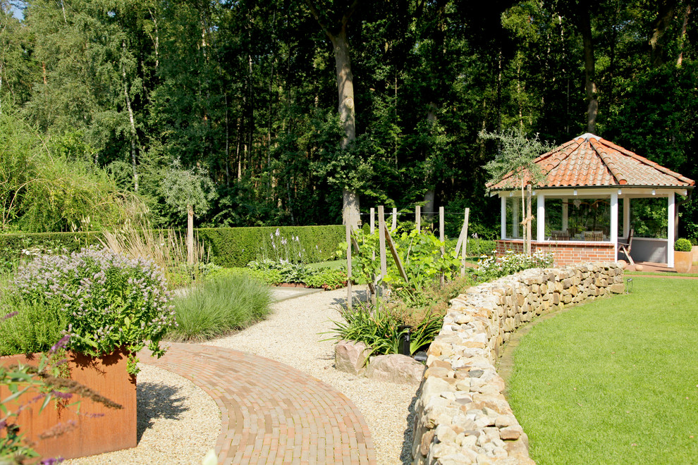 Große Landhaus Gartenmauer mit direkter Sonneneinstrahlung und Pflastersteinen in Sonstige