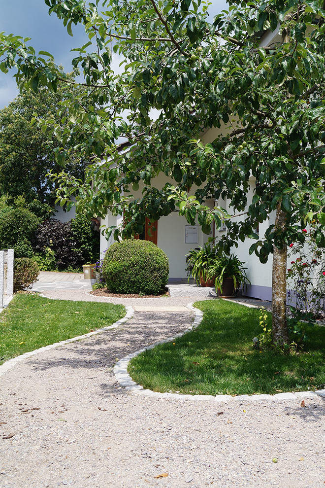 Cette image montre un aménagement d'entrée ou allée de jardin avant design de taille moyenne et l'été avec une exposition partiellement ombragée et du gravier.