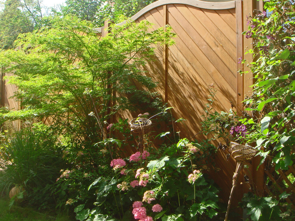 Exemple d'un aménagement d'entrée ou allée de jardin arrière nature de taille moyenne et l'été avec une exposition partiellement ombragée et une terrasse en bois.