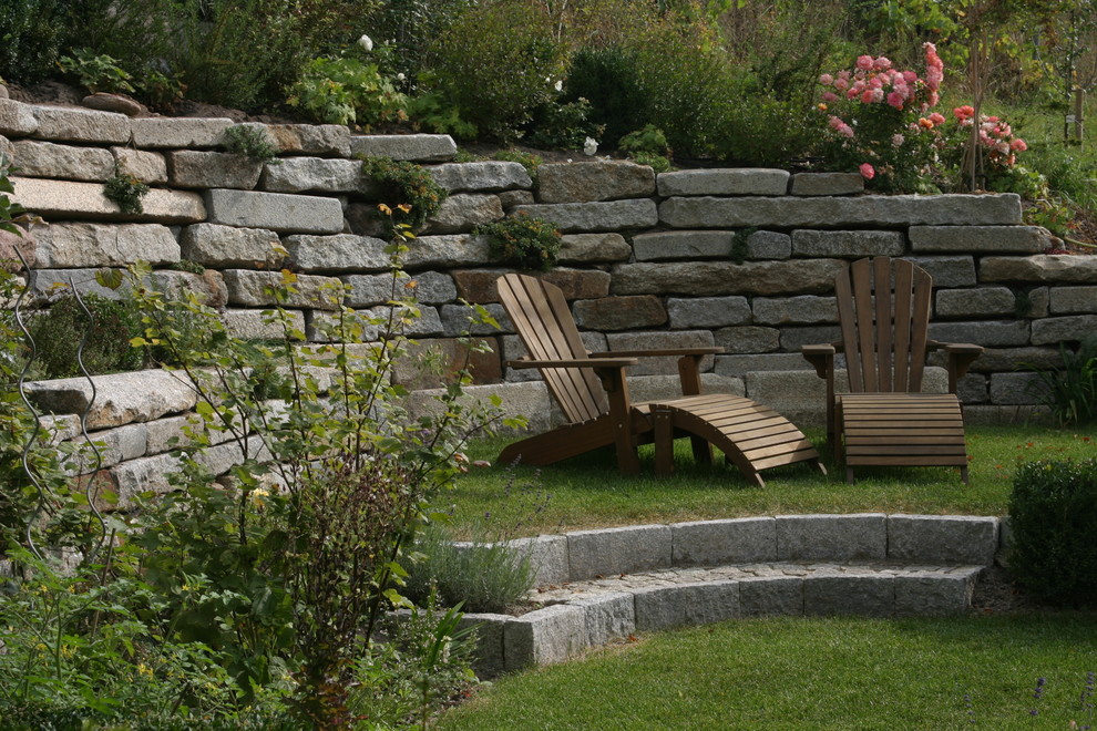 На фото: участок и сад среднего размера в классическом стиле с подпорной стенкой и покрытием из каменной брусчатки