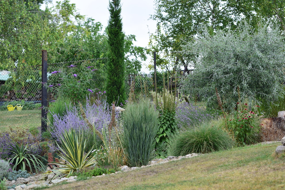 Ispirazione per un giardino xeriscape mediterraneo esposto in pieno sole di medie dimensioni in estate con un pendio, una collina o una riva e ghiaia