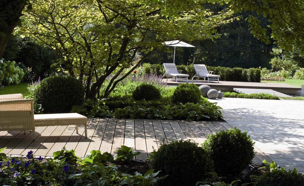 Idéer för en stor klassisk bakgård i delvis sol på sommaren, med trädäck och en fontän