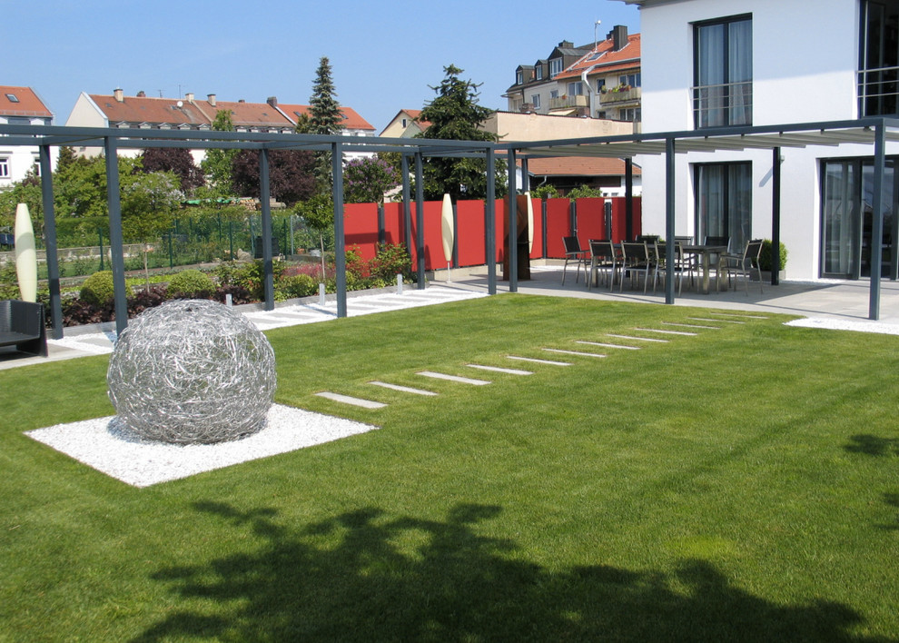 Großer Moderner Gartenweg hinter dem Haus, im Sommer mit direkter Sonneneinstrahlung und Natursteinplatten in Nürnberg