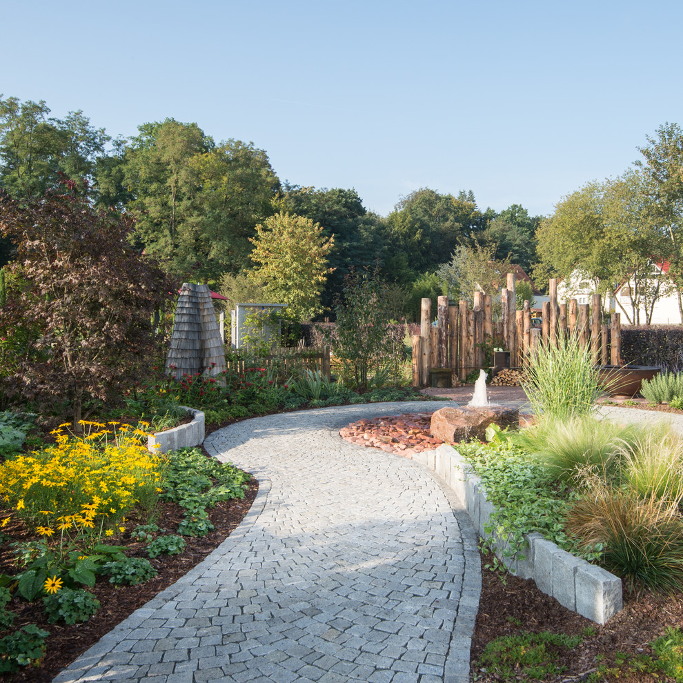 Foto de jardín contemporáneo grande en verano con exposición parcial al sol y adoquines de piedra natural