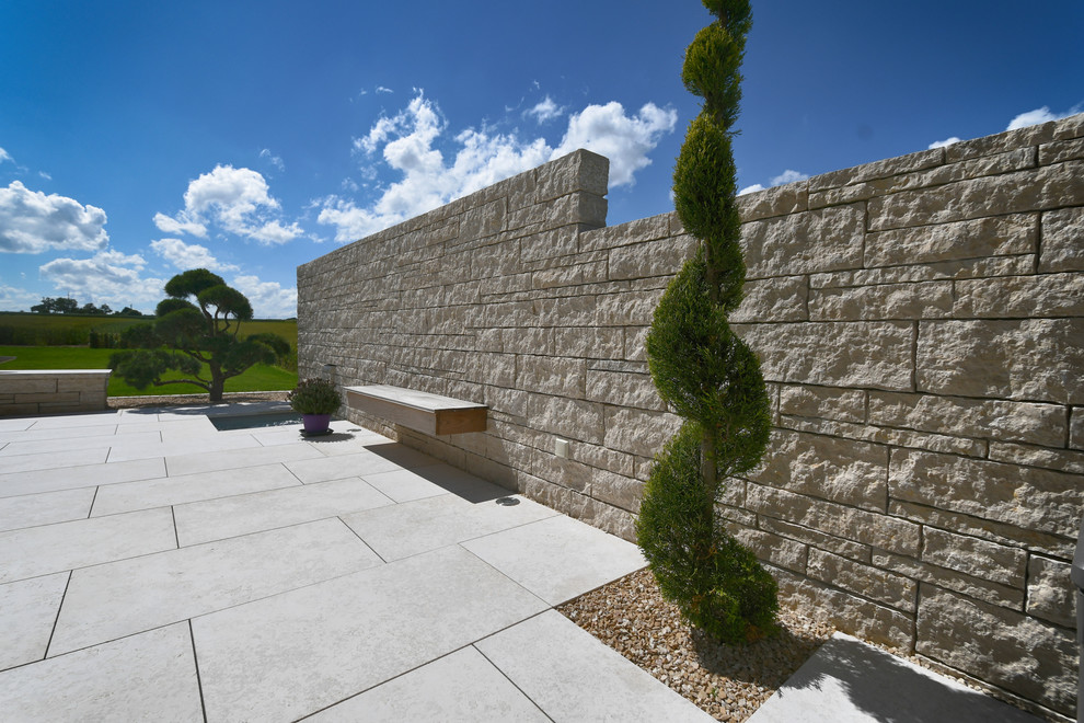 Esempio di un ampio giardino formale design esposto in pieno sole dietro casa in estate con un giardino in vaso e pavimentazioni in mattoni