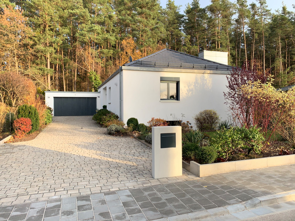 Design ideas for a large contemporary partial sun front yard concrete paver landscaping in Nuremberg for fall.