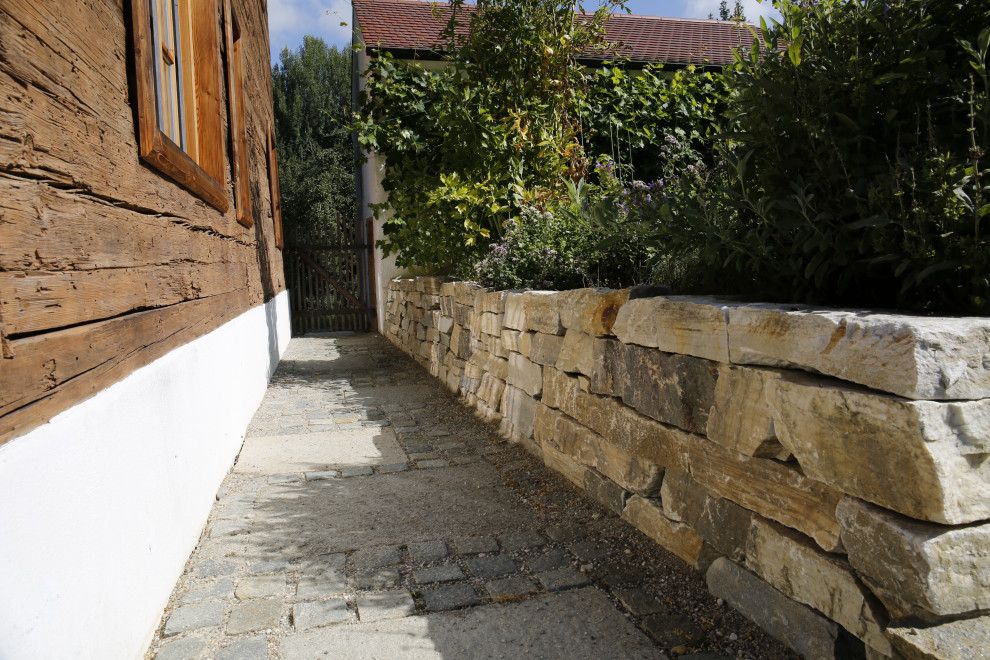 Esempio di un ampio giardino stile rurale esposto in pieno sole in cortile con un ingresso o sentiero e pavimentazioni in pietra naturale