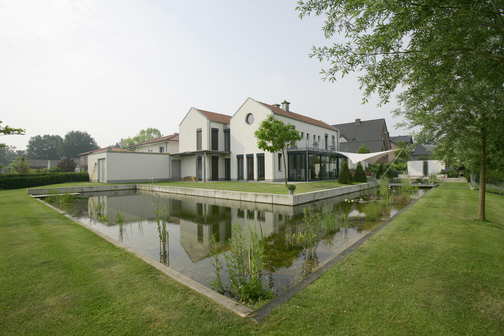 Foto di un ampio giardino design esposto in pieno sole dietro casa in estate con fontane e pavimentazioni in cemento