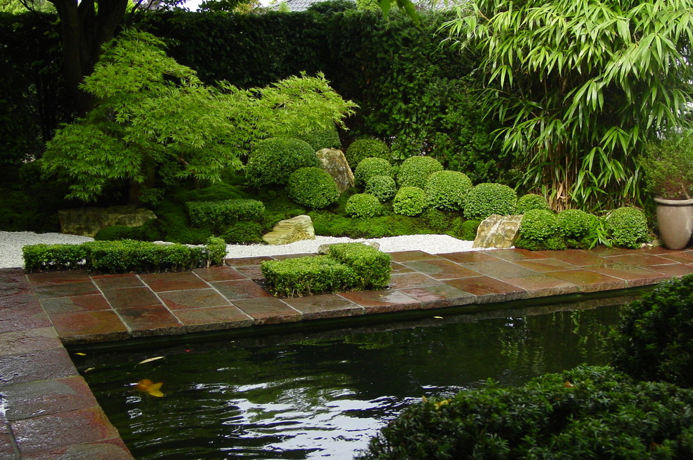 Foto di un laghetto da giardino etnico esposto a mezz'ombra di medie dimensioni e nel cortile laterale in estate con pavimentazioni in pietra naturale