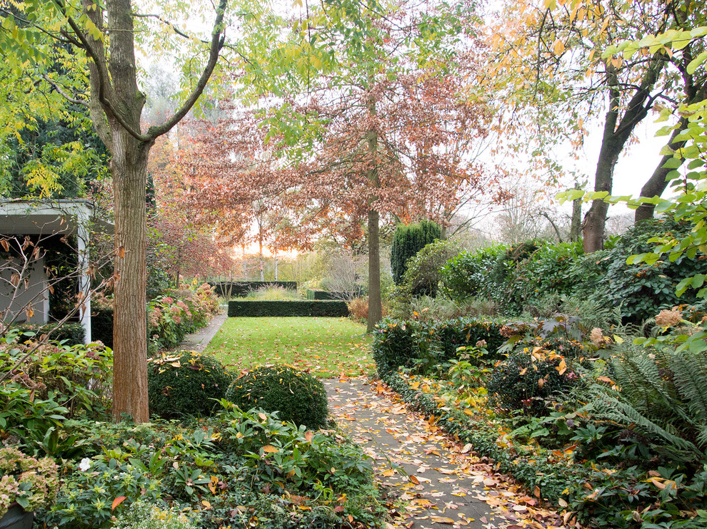 На фото: осенний регулярный сад среднего размера на боковом дворе в классическом стиле с садовой дорожкой или калиткой, полуденной тенью и мощением тротуарной плиткой с